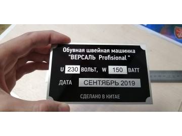 Тот же шильдик «ВЕРСАЛЬ Profisional» в руке (показ масштаба), на заднем плане линейка — лазерная гравировка по дереву Уфа — НеоШтамп