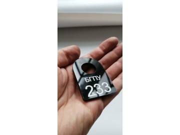 Тот же «БГПУ 233» в раскрытой ладони (показ масштаба), фон — номерки для гардероба Уфа — НеоШтамп